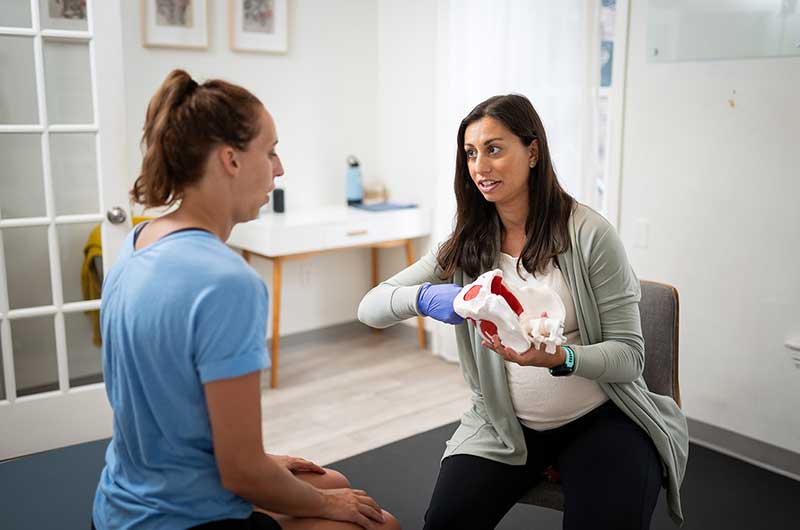 Jules explaining pelvic therapy to a patient